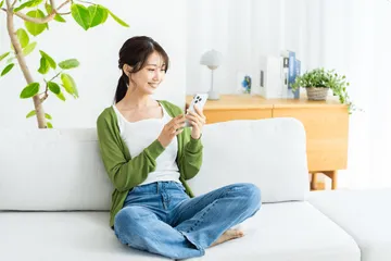 ソファーでスマホを操作している女性